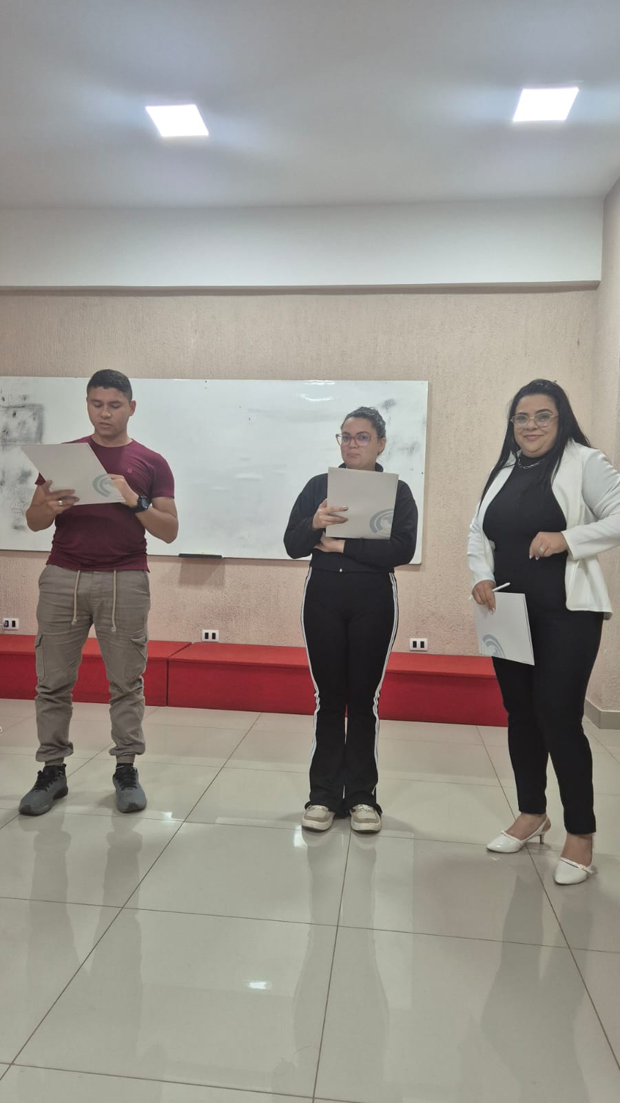 Estudantes com certificados em frente ao quadro branco
