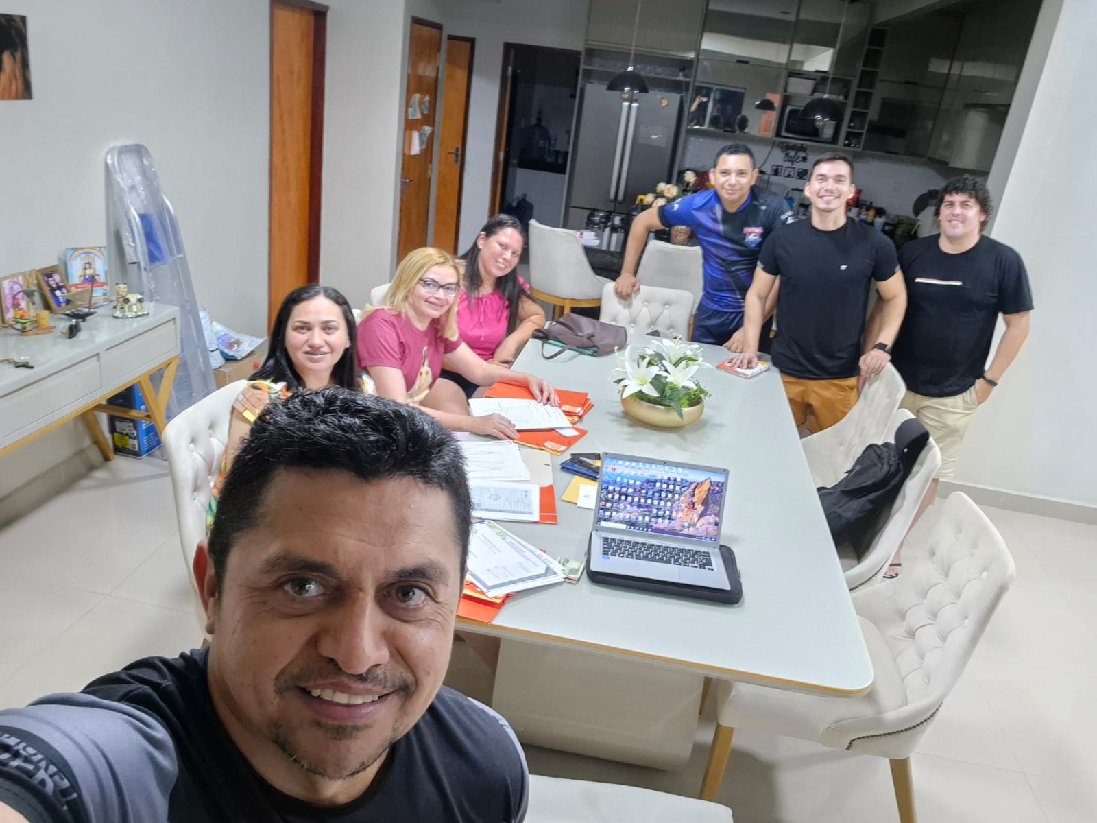Equipe reunida em mesa de reunião com documentos